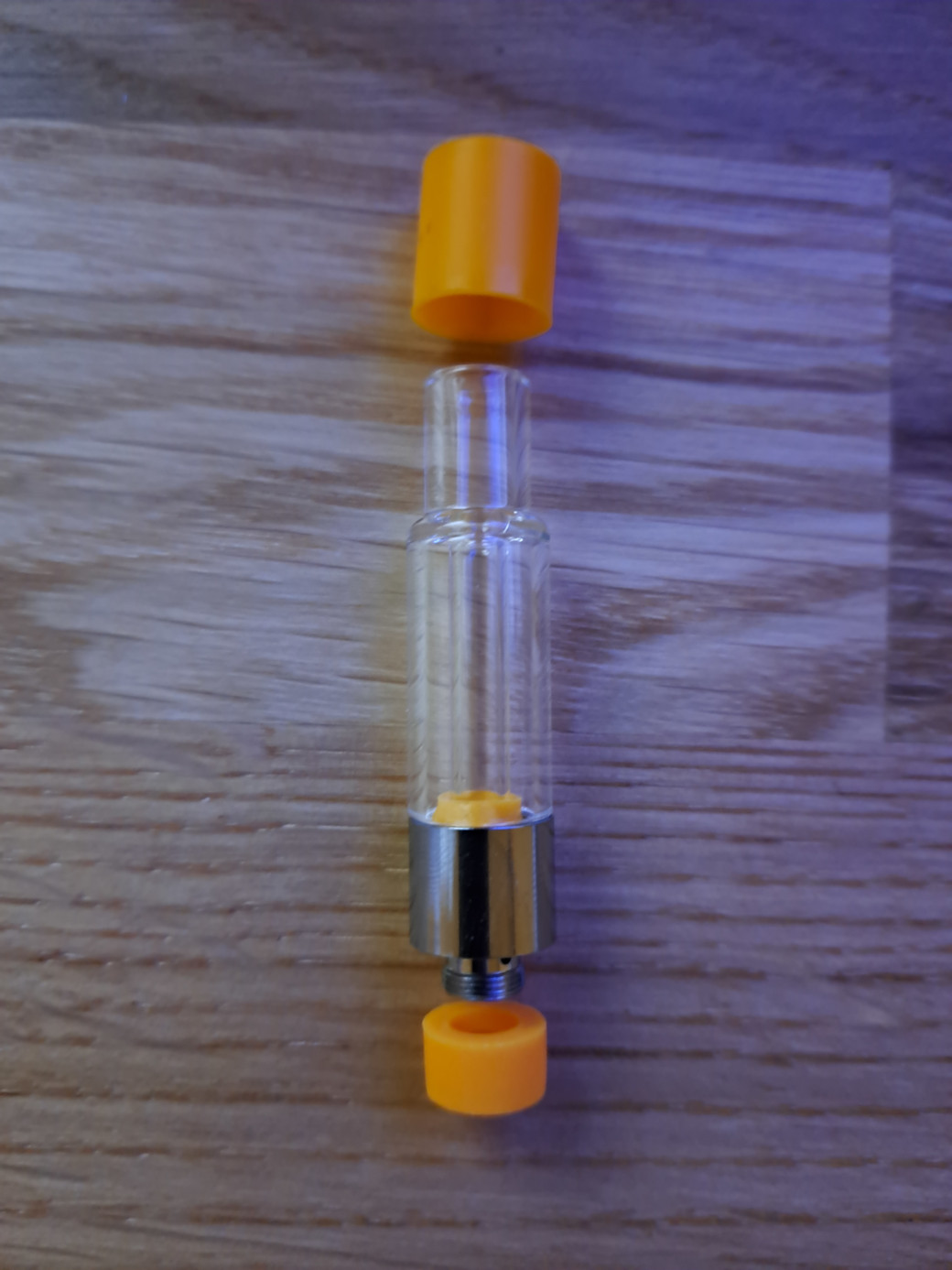 A clear glass bottle with an orange lid, designed for VG02 - 1ml - Full Glass vape cartridges.